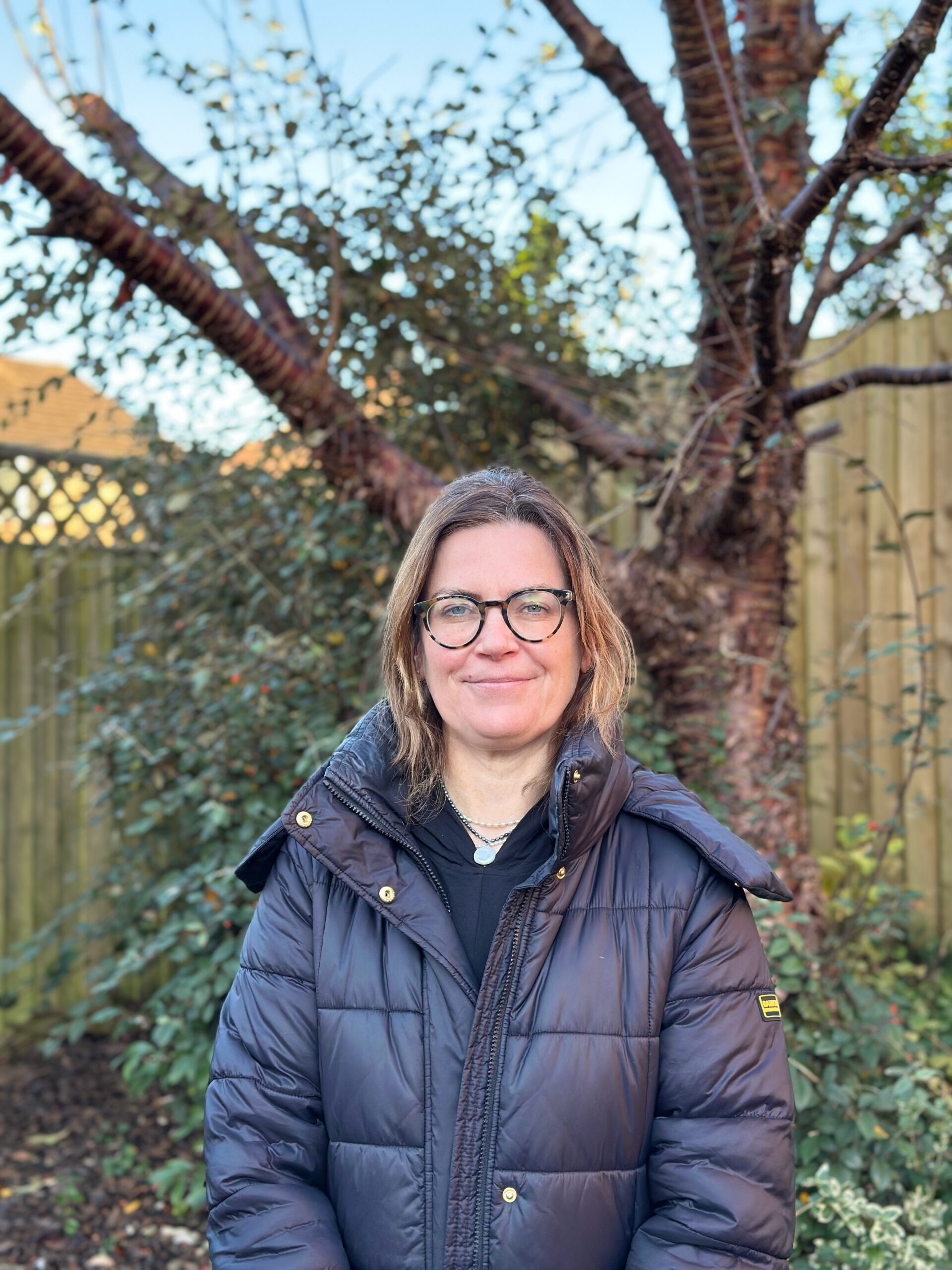 Carmel standing in front of a tree