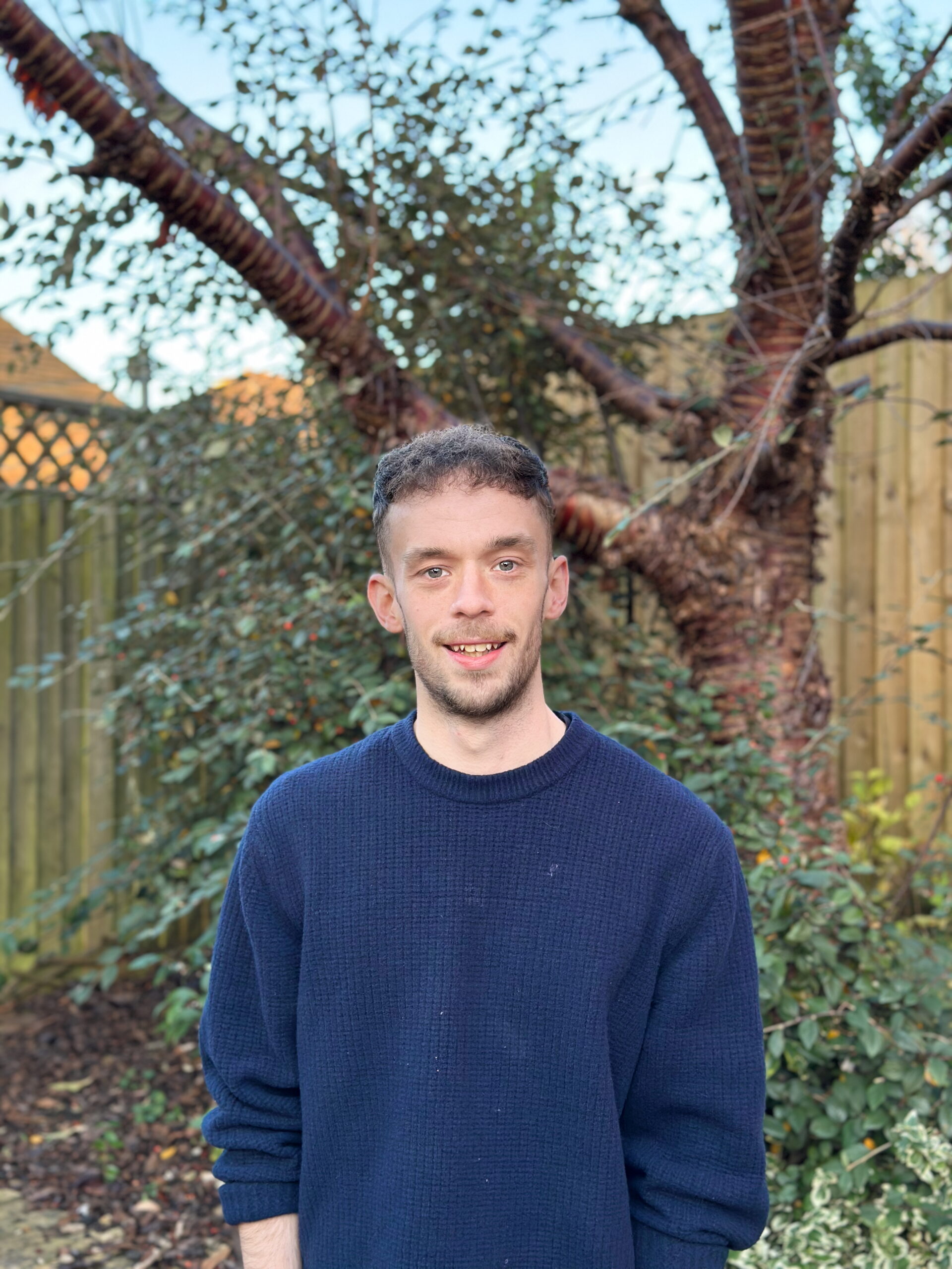 Jamie standing in front of a tree