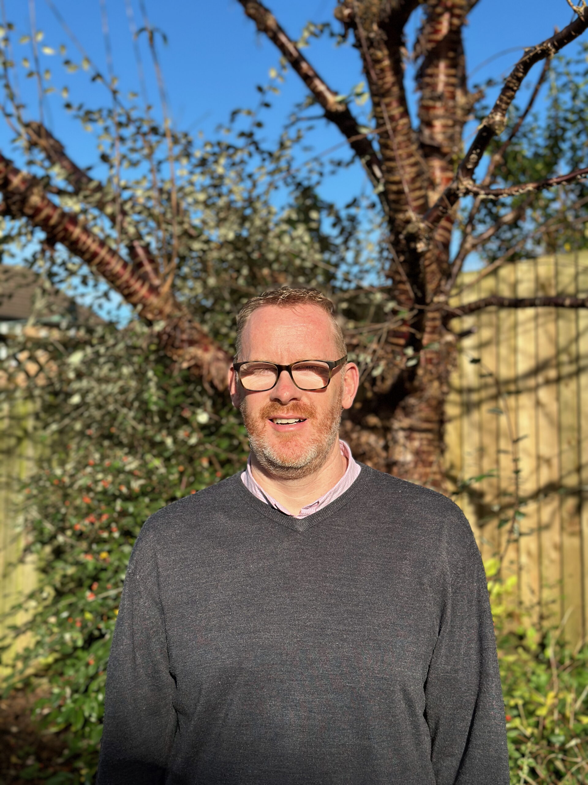 Andy standing in front of a tree