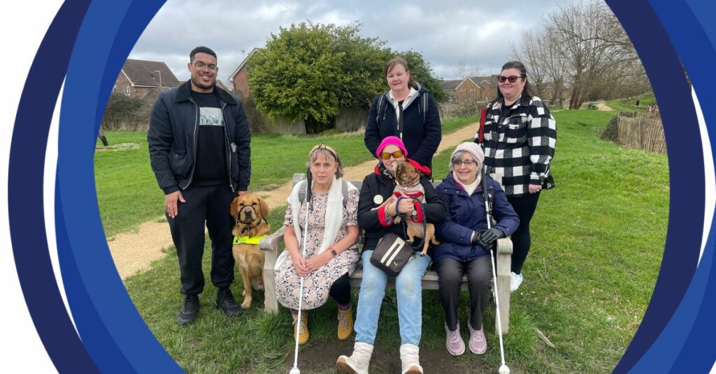 Susan (front right) with 5 other people and 1 guide dog posing for a photo during one of the green walk group outings