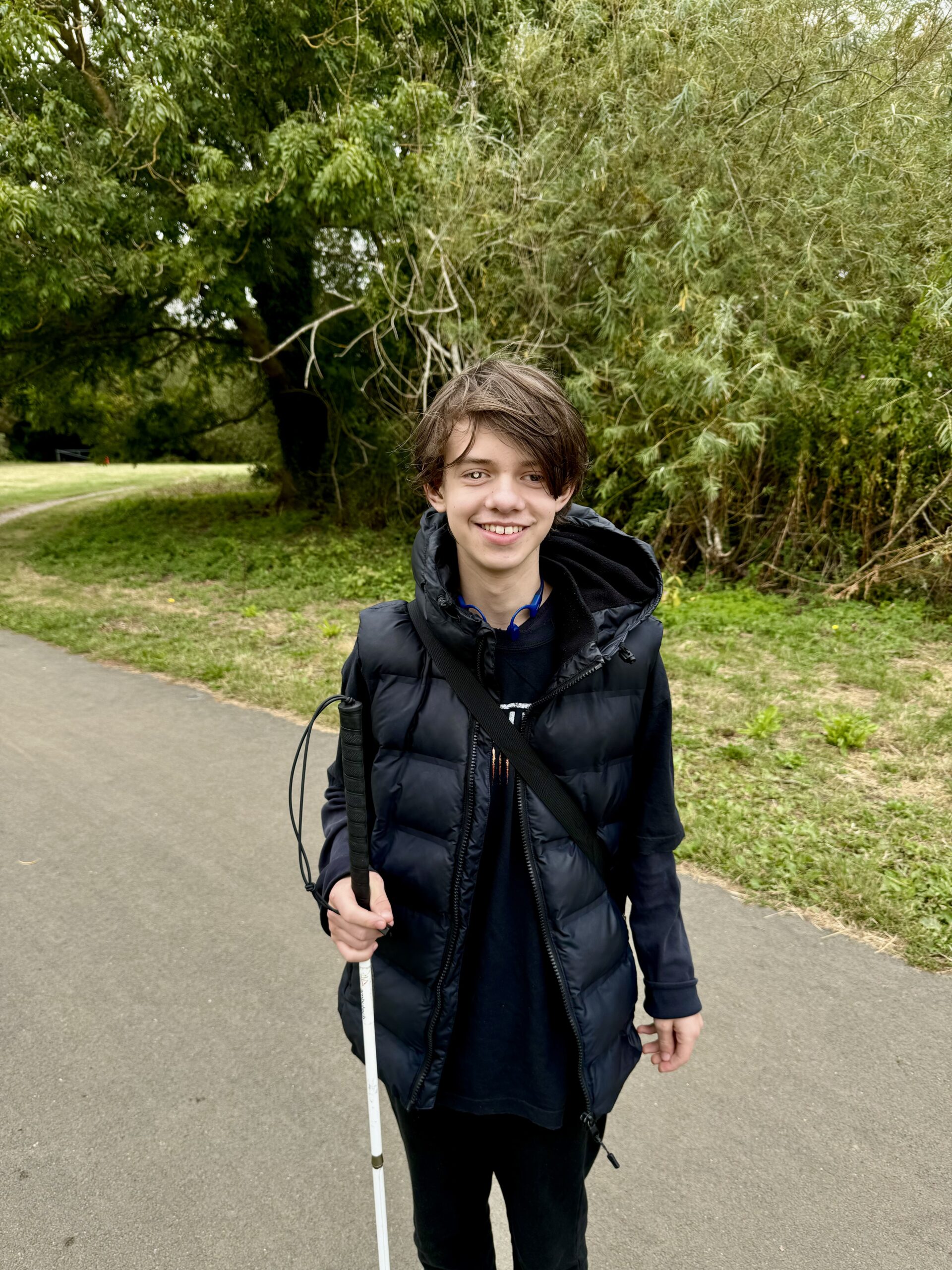 Image Description: Daniel, with his white cane, smiling at the camera