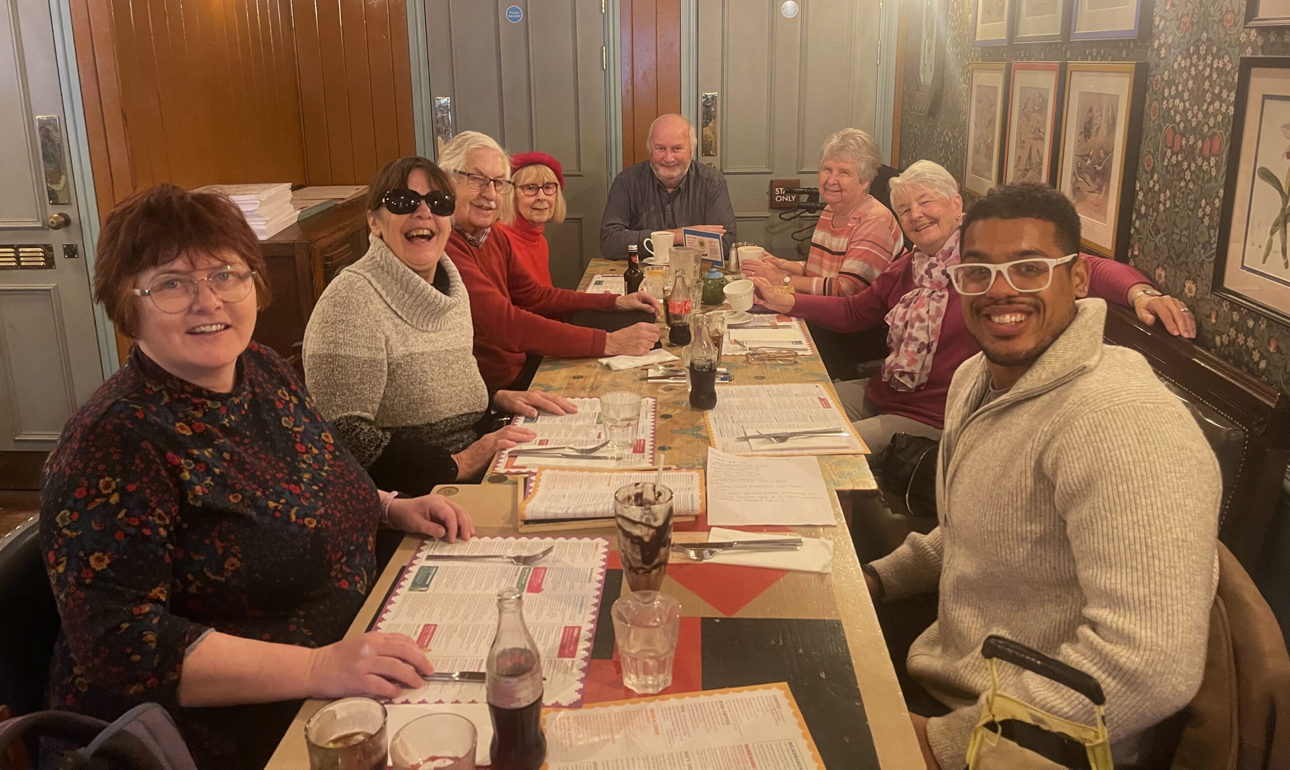 a group of people sitting in a restaurant looking at menus