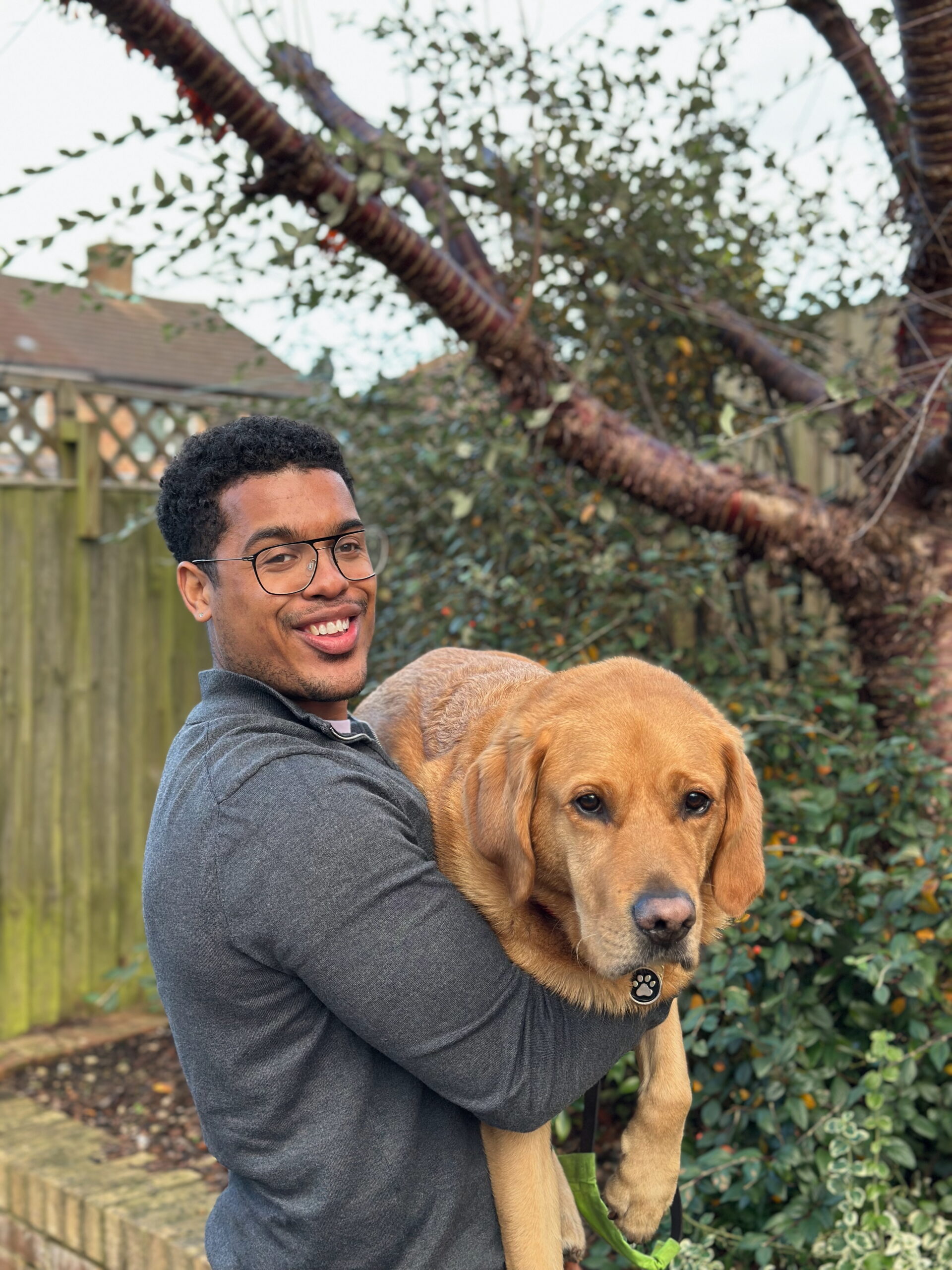 Devante standing in front of a tree holding Mack