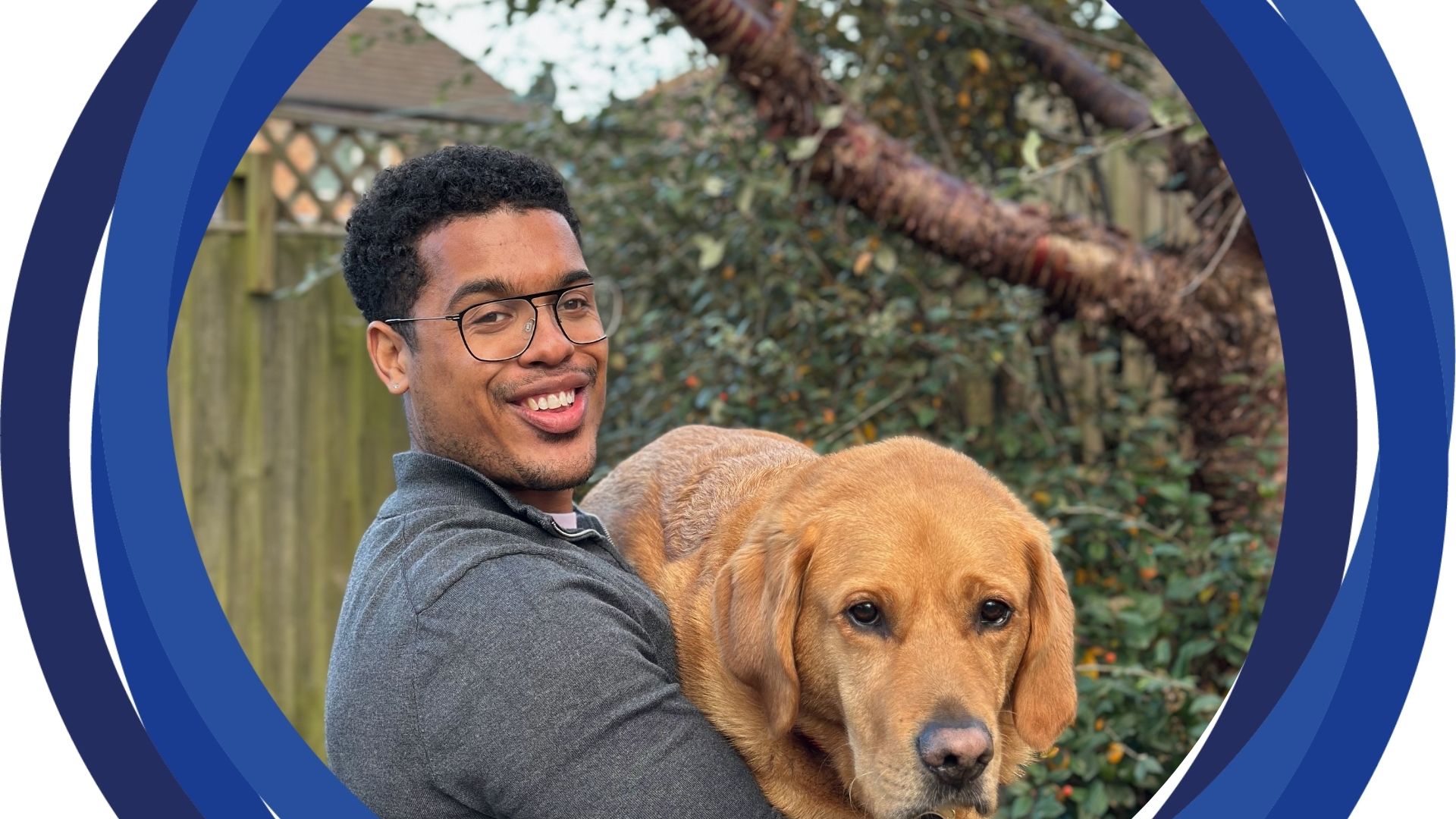 Devante staning in front of a tree holding Mack